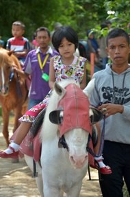 Anak-anak menunggangi Kuda Poni yang dipandu oleh petugas Taman Rimba Jambi